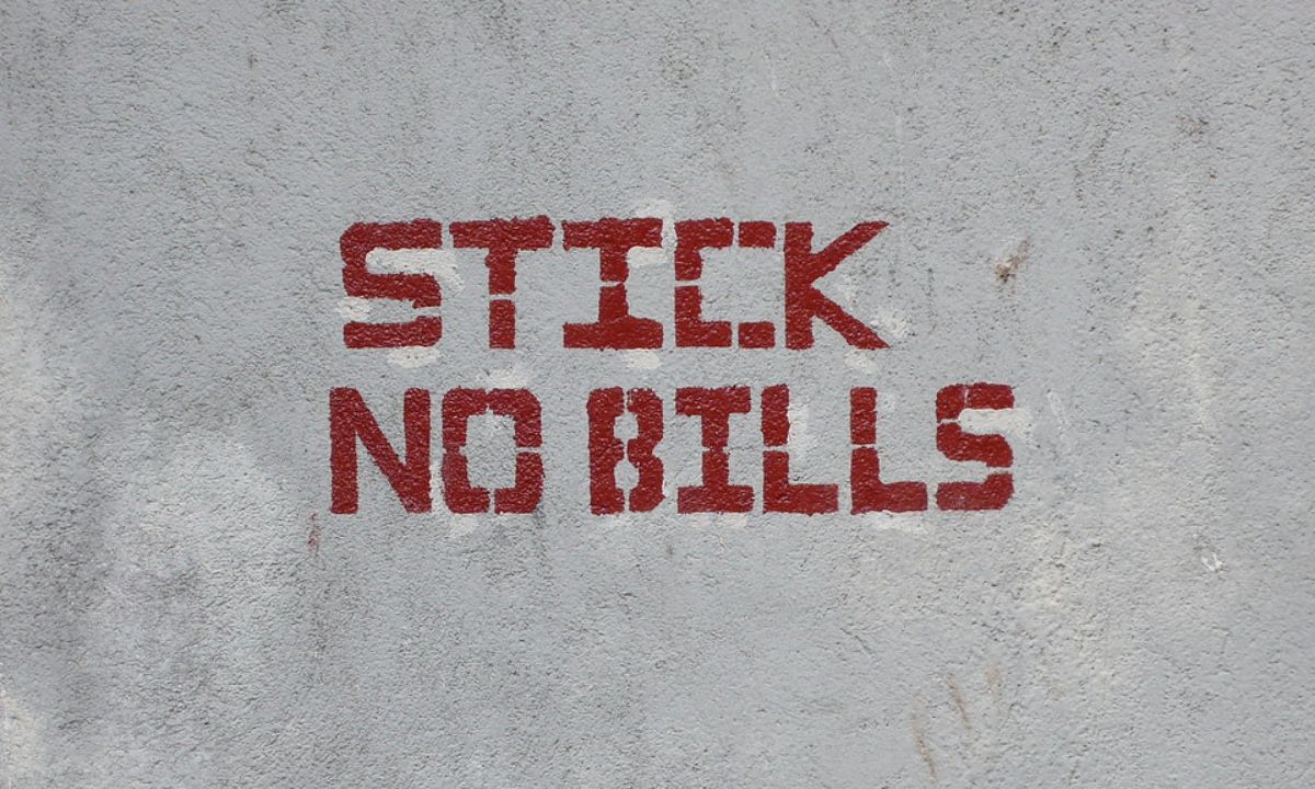 A clean public space with 'Stick No Bills' signs, showcasing a vibrant cityscape in the background.